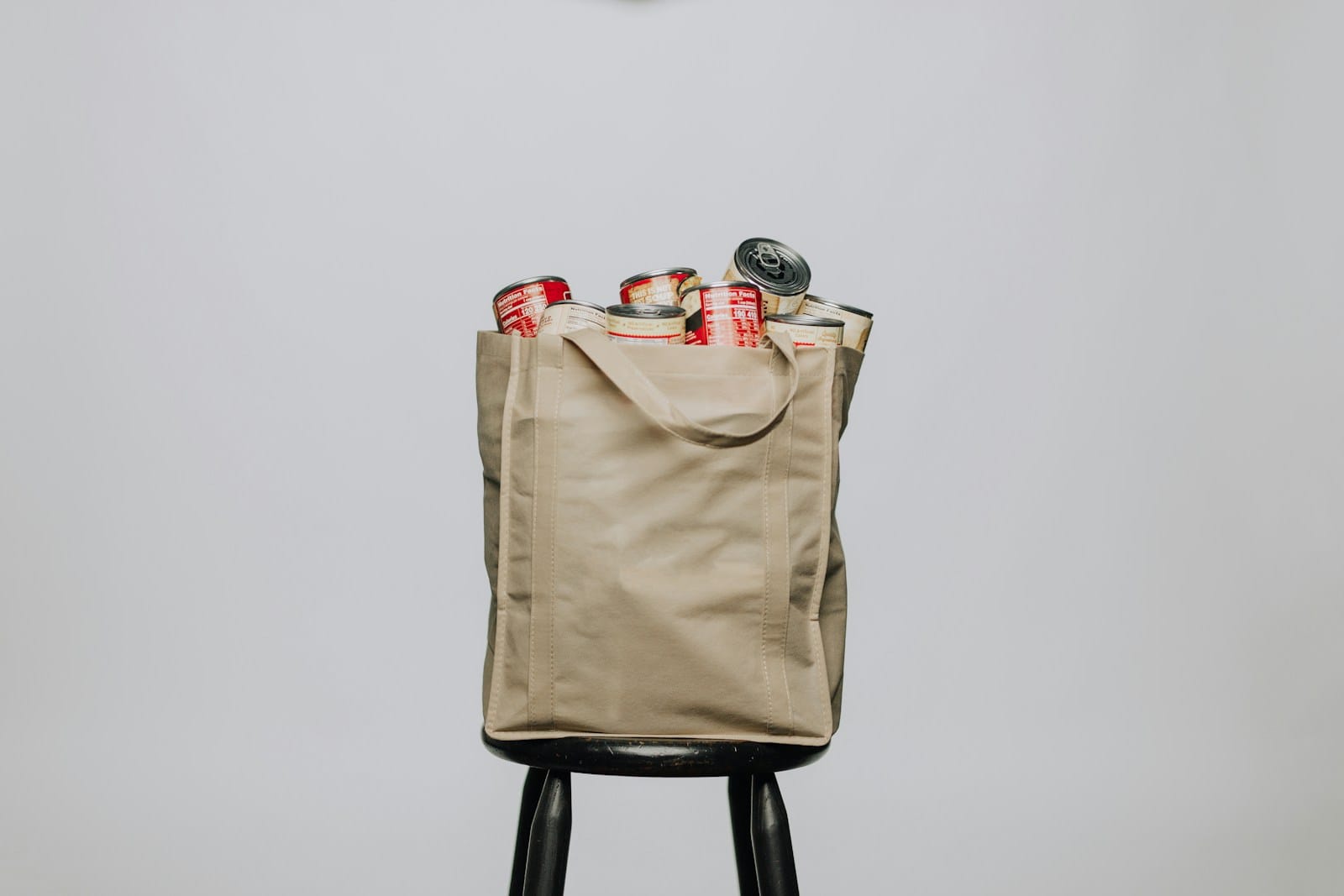 red labeled cans on white fabric handbag